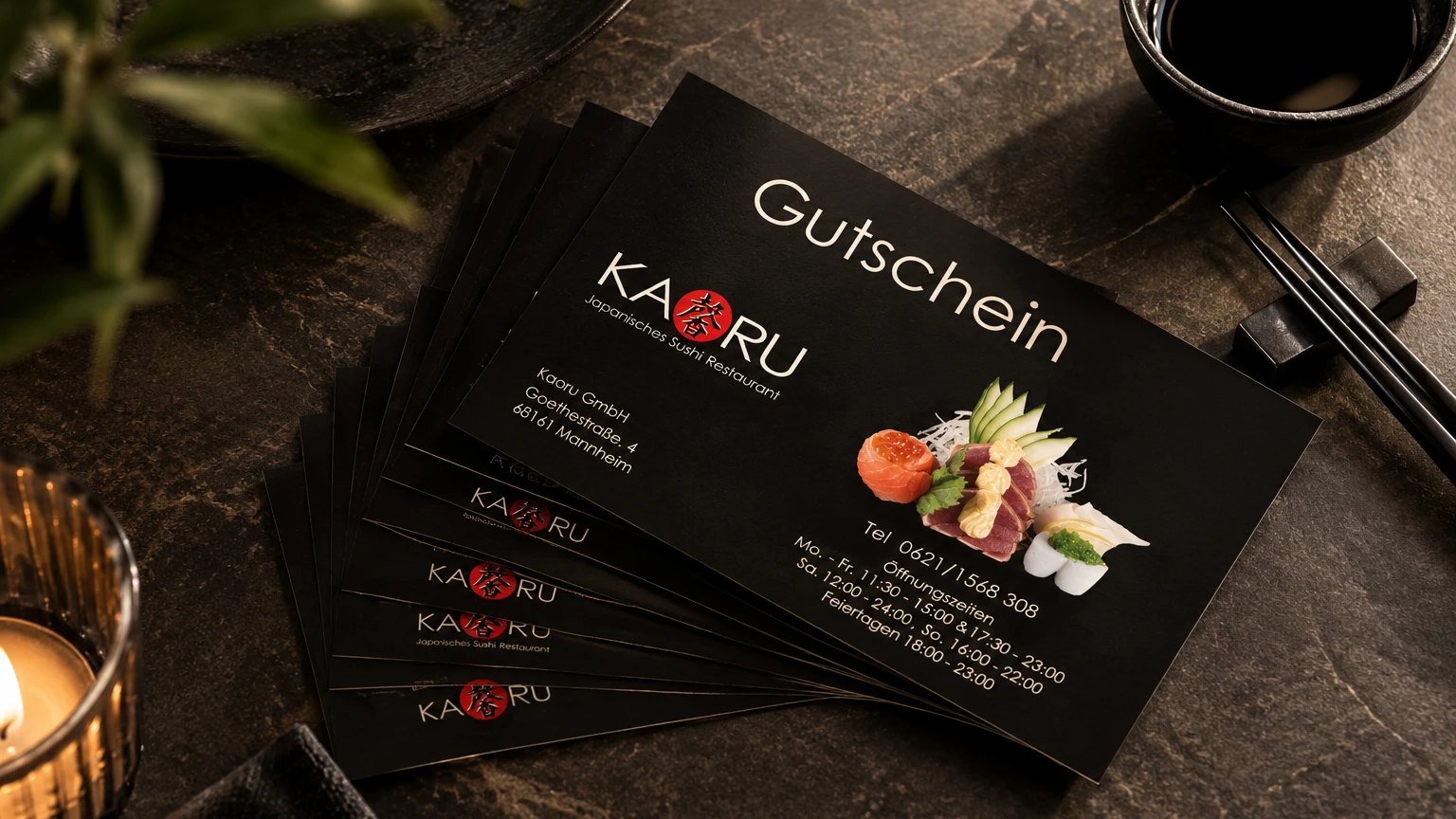 Mehrere KAORU Gutscheinkarten gefächert auf einem dunklen Steintisch